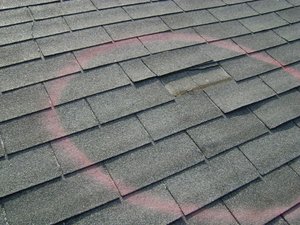 A professional roofing contractor conducting a roof inspection on a residential home.
