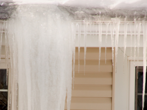Ice dam forming on the edge of a snow-covered roof in Springfield.